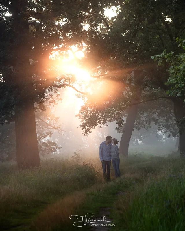 Zdjęcie pary spacerującej w lesie o wschodzie słońca
